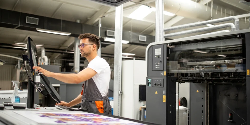 Technician working on advanced printing equipment – Digital Printing Services in UAE.